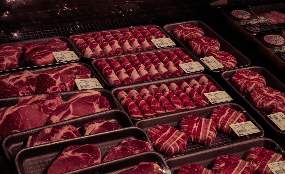 Raw meat cuts in trays in refrigerated display